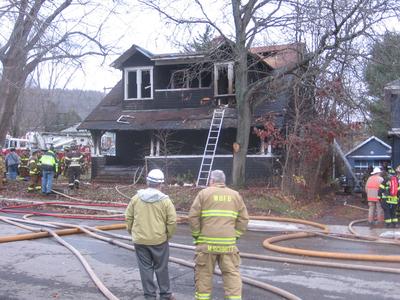 Pets survived this fire bungalow house after a fire with people standing.